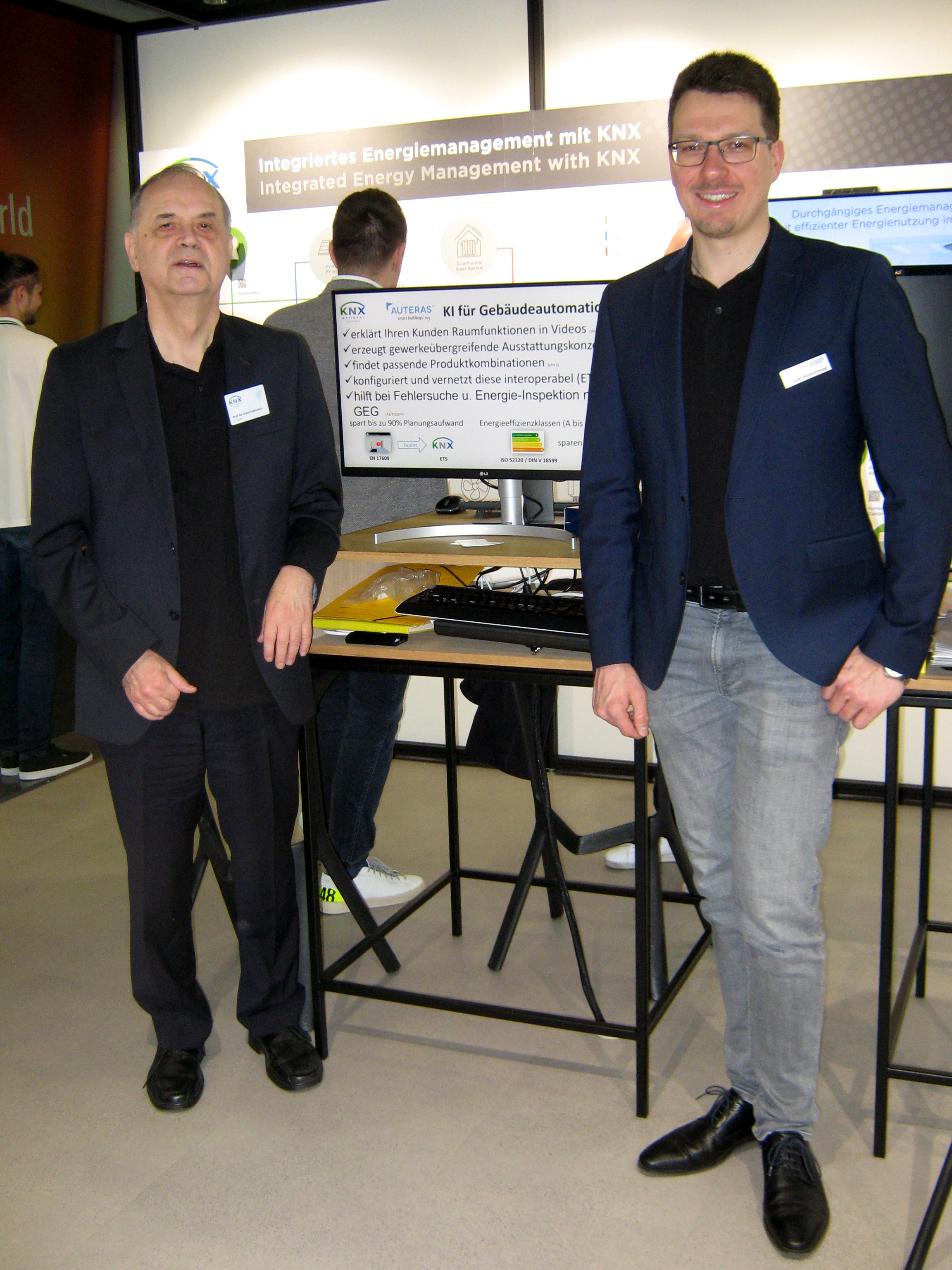 Foto: Prof. Kabitzsch und Bastian Wollschlaeger am Messestand vor AUTERAS-Bildschirm
